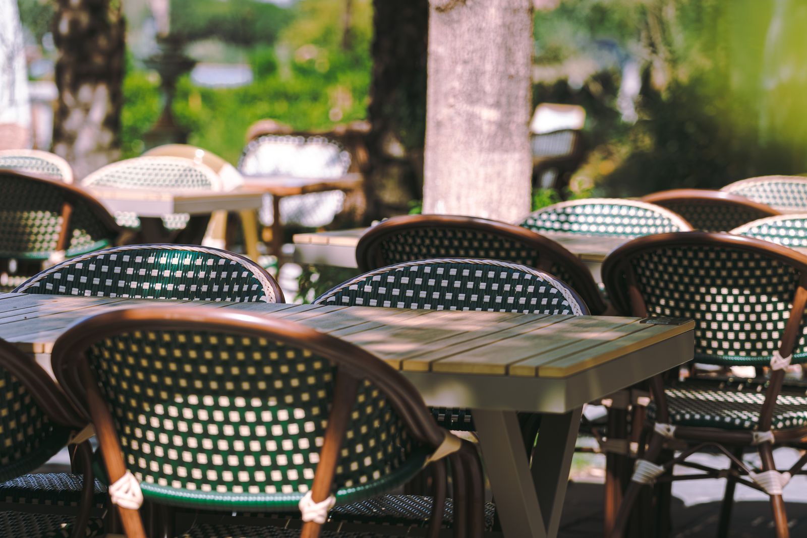 Woven bistro chairs around tables on a shaded outdoor patio, the kind of seating found at Westlake FL restaurants and their neighbors